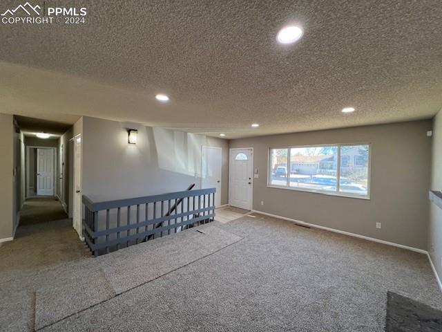 basement featuring carpet and a textured ceiling