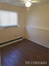 unfurnished room with dark hardwood / wood-style floors and a baseboard radiator