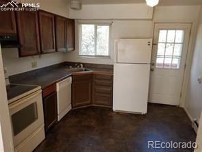 kitchen with white appliances, sink, and a wealth of natural light