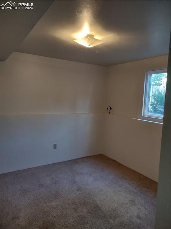 spare room with carpet flooring and lofted ceiling