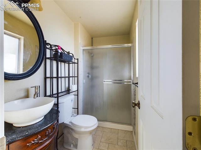 bathroom with tile patterned floors, vanity, toilet, and walk in shower