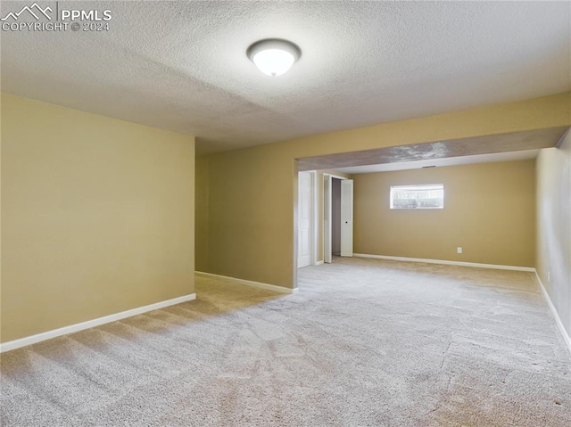 empty room featuring light colored carpet and a textured ceiling