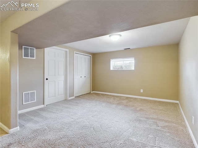 basement featuring light carpet