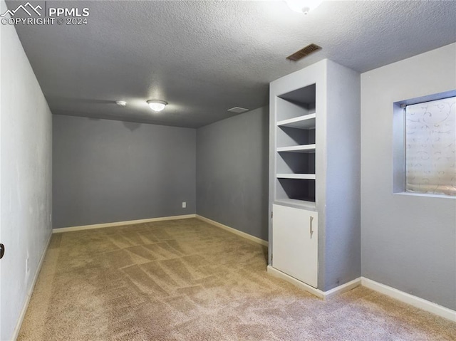 carpeted spare room with a textured ceiling