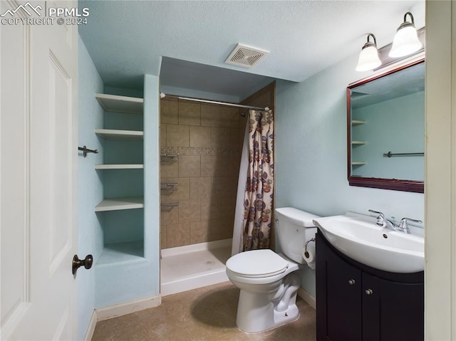 bathroom featuring a shower with shower curtain, vanity, toilet, and a textured ceiling