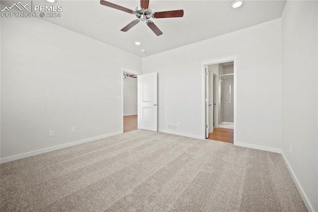 unfurnished bedroom with ceiling fan, light colored carpet, and ensuite bath