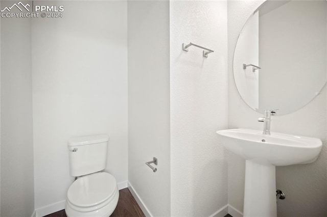 bathroom featuring hardwood / wood-style flooring and toilet