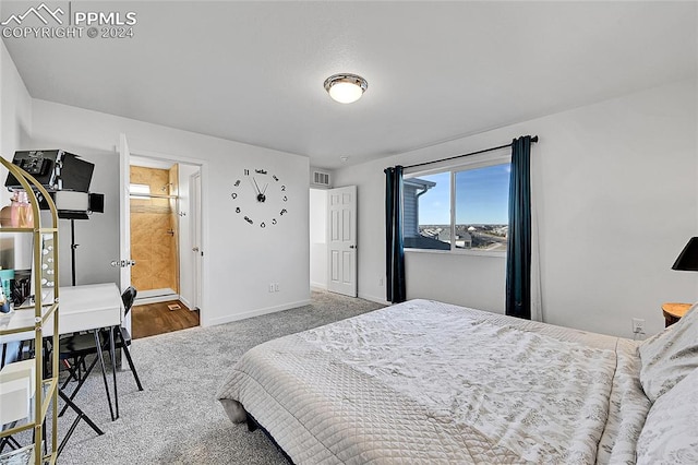 carpeted bedroom featuring ensuite bath