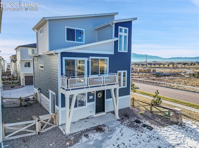 back of property featuring a mountain view and a balcony