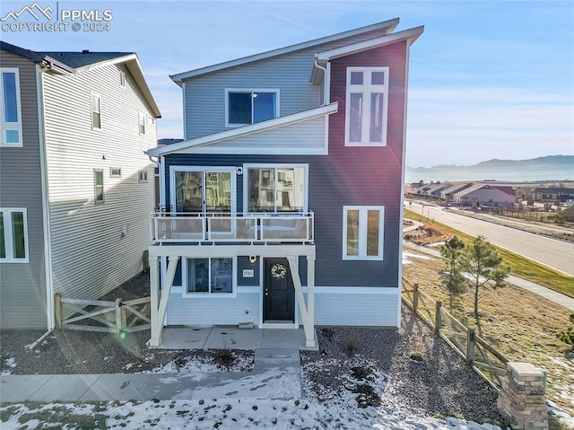 view of front of property featuring a mountain view and a balcony