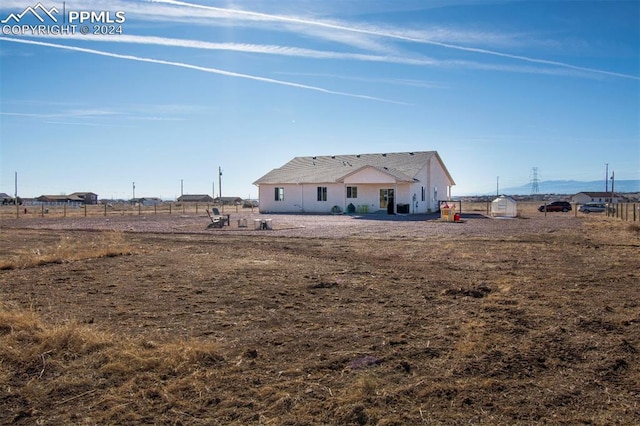 rear view of house featuring a rural view