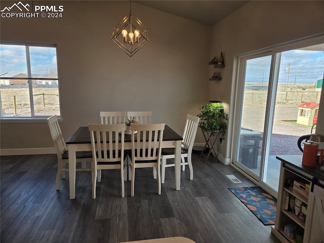 dining area with a notable chandelier, dark hardwood / wood-style flooring, and vaulted ceiling