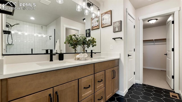 bathroom with tile patterned flooring, vanity, and tiled shower