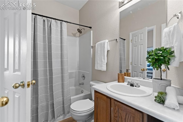 full bathroom featuring shower / bath combination with curtain, vanity, and toilet