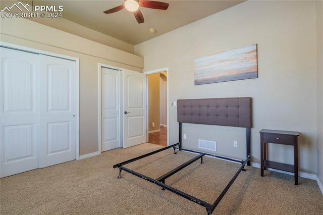 bedroom featuring carpet floors, ceiling fan, and multiple closets