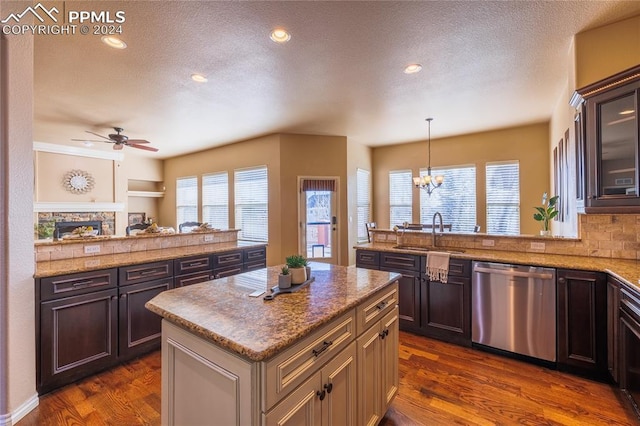 kitchen featuring kitchen peninsula, sink, decorative light fixtures, dishwasher, and a center island