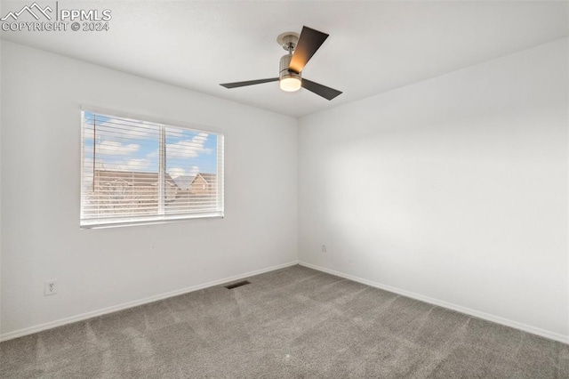 carpeted spare room with ceiling fan