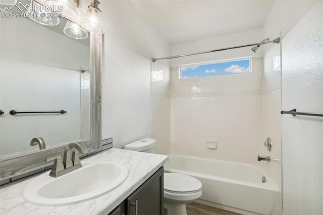 full bathroom with vanity, tiled shower / bath, and toilet