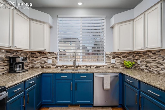 kitchen with stainless steel dishwasher, light stone counters, blue cabinets, and sink