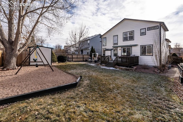 back of property with a shed, a deck, and a yard