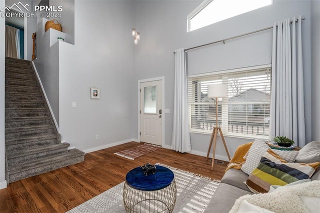 living room featuring wood-type flooring and a towering ceiling