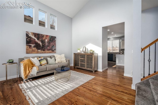 living room with high vaulted ceiling, dark wood-type flooring, and sink