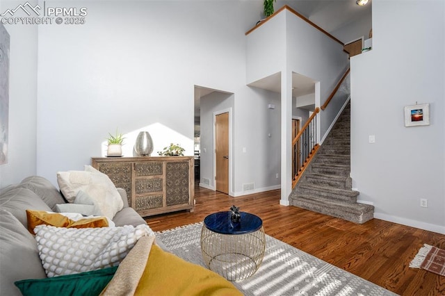 living room with a high ceiling and hardwood / wood-style flooring