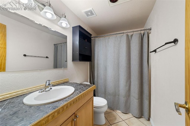 bathroom featuring tile patterned flooring, vanity, and toilet