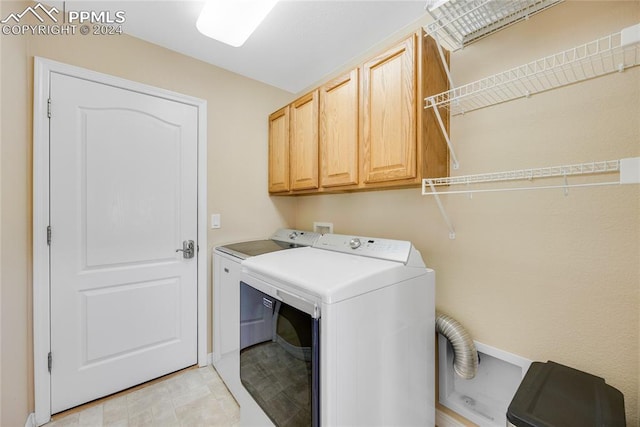 laundry room with cabinets and washing machine and clothes dryer