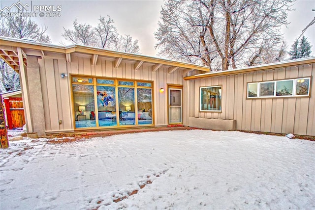 view of snow covered rear of property