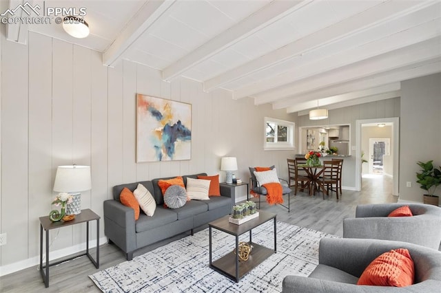 living room with beamed ceiling, wood-type flooring, and wood walls