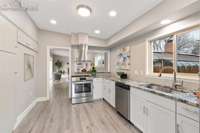 kitchen with light stone countertops, sink, white cabinets, and appliances with stainless steel finishes