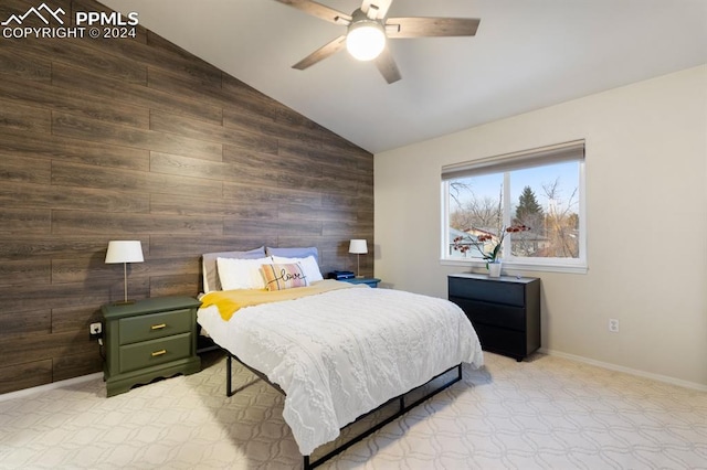 bedroom featuring vaulted ceiling, ceiling fan, and wooden walls