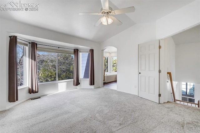 empty room with carpet flooring, vaulted ceiling, and ceiling fan