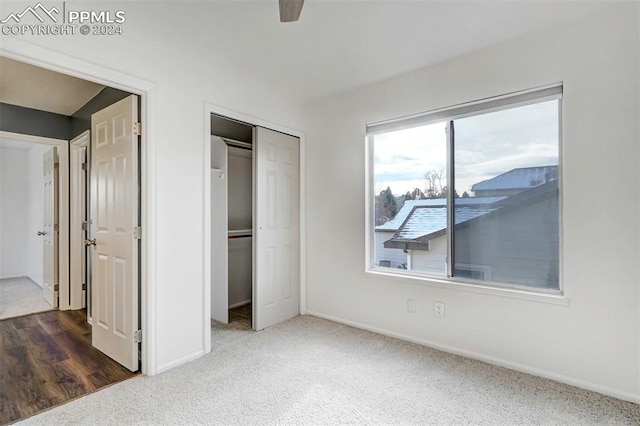 unfurnished bedroom featuring ceiling fan, dark wood-type flooring, and a closet