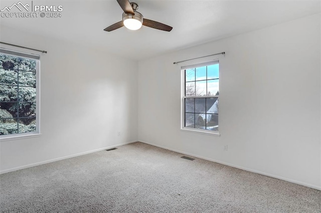 carpeted spare room featuring ceiling fan