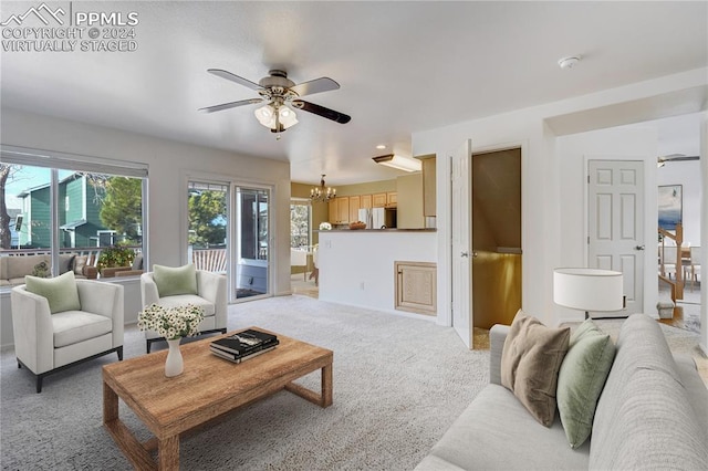 living room with carpet and ceiling fan with notable chandelier