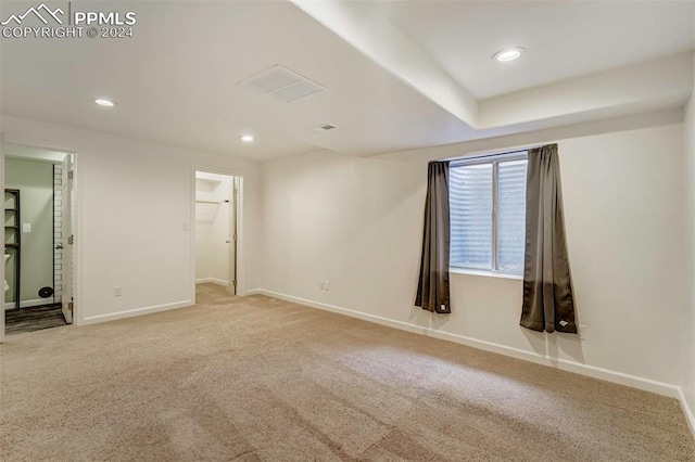 unfurnished bedroom with light carpet and a spacious closet