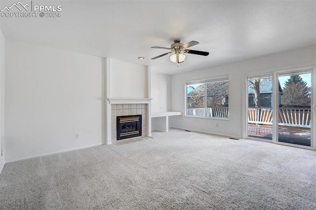 unfurnished living room featuring a fireplace, light carpet, and ceiling fan