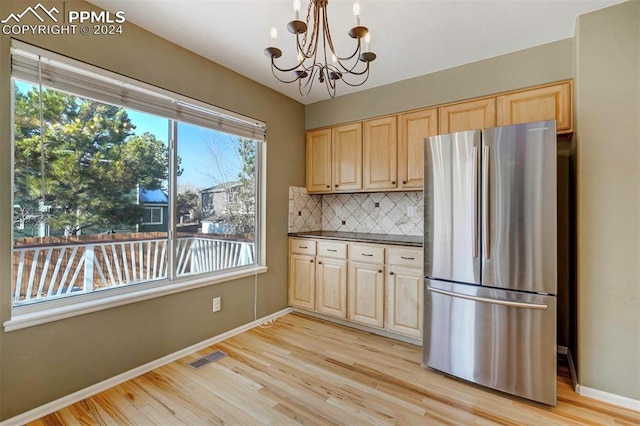 kitchen featuring decorative light fixtures, stainless steel fridge, light wood-type flooring, and a chandelier