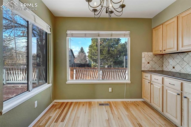 unfurnished dining area featuring light hardwood / wood-style floors and a chandelier