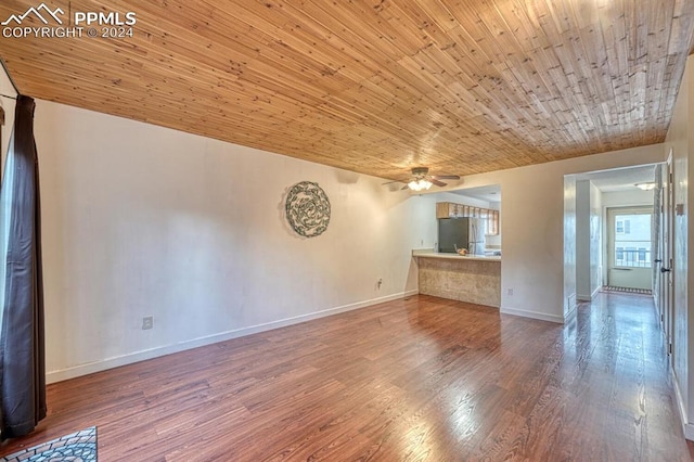 unfurnished living room with ceiling fan, wood ceiling, and hardwood / wood-style flooring