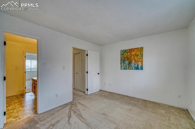 carpeted spare room with a textured ceiling