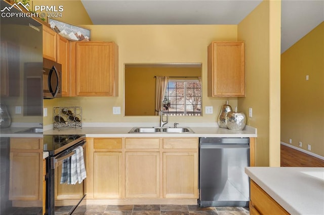 kitchen featuring appliances with stainless steel finishes, light brown cabinets, vaulted ceiling, and sink