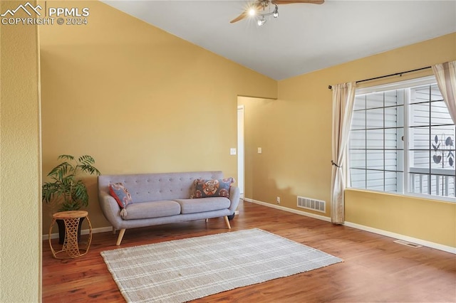 living area with wood-type flooring, vaulted ceiling, and ceiling fan