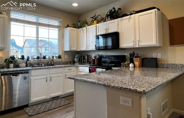 kitchen with black appliances, sink, light hardwood / wood-style flooring, light stone counters, and white cabinetry