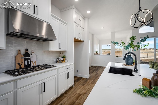 kitchen with sink, stainless steel gas cooktop, dark hardwood / wood-style flooring, decorative backsplash, and white cabinets