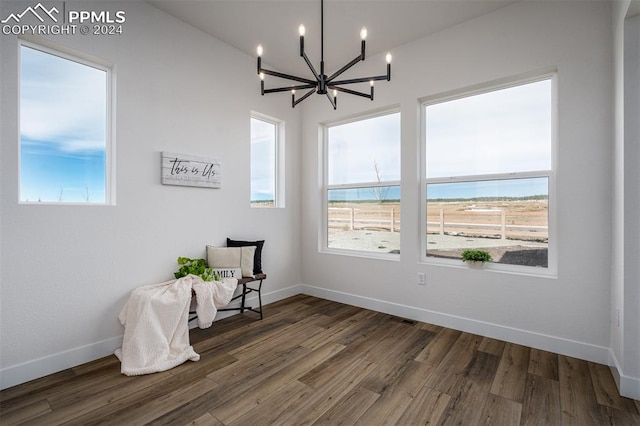 living area with dark hardwood / wood-style floors and a notable chandelier