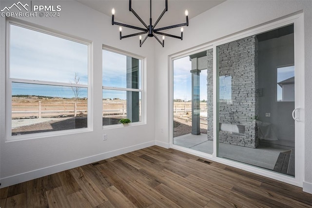 empty room featuring hardwood / wood-style flooring and a chandelier