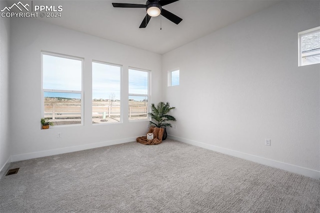 carpeted spare room featuring a water view and ceiling fan